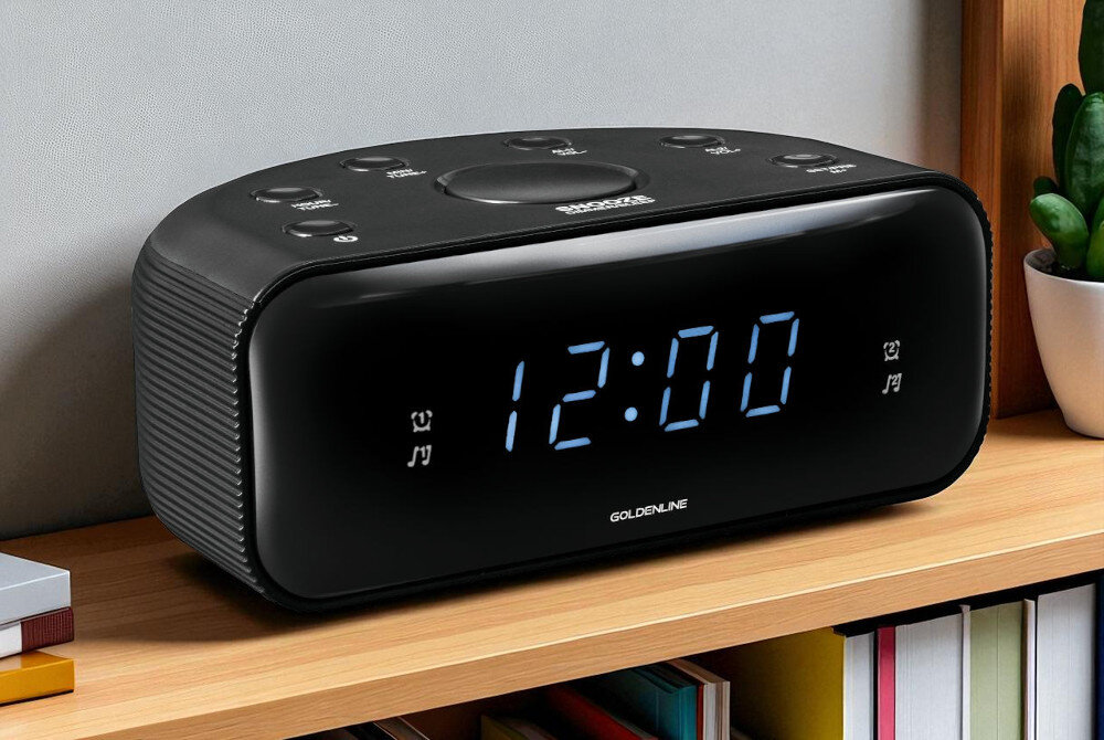 Radiobudzik GOLDENLINE RCL200 na półce z dekoracjami poniżej książki