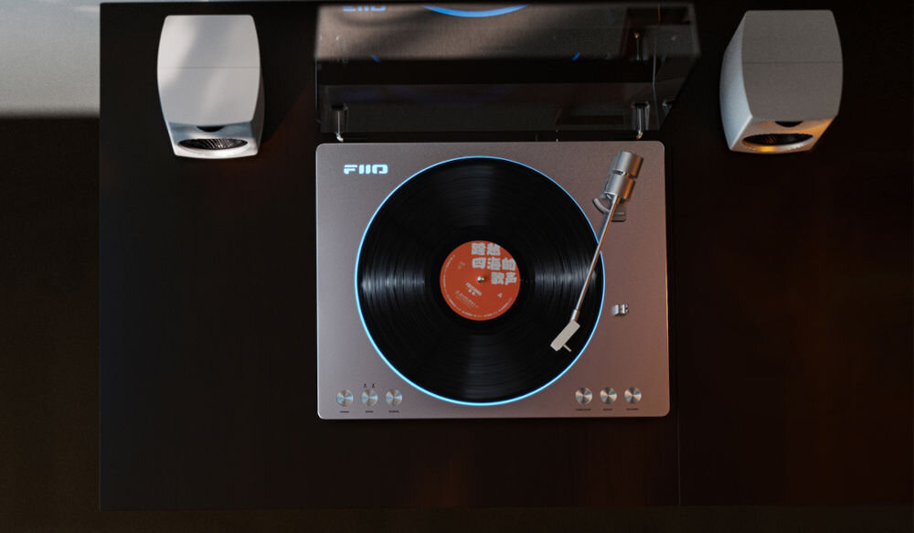 Gramofon FIIO TT13 BT analogowe audio wzmacniacze JRC5532 czysty dźwięk, gramofon od góry na czarnym stole pomiędzy głośnikami
