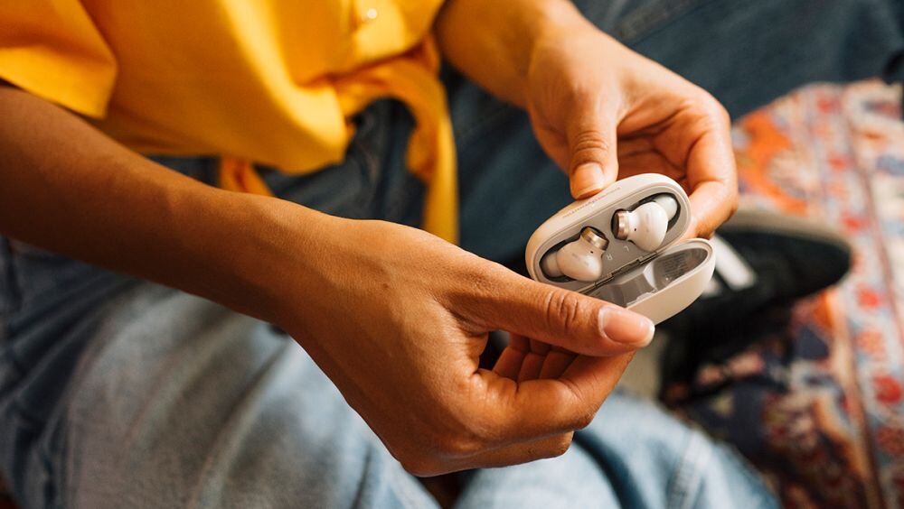 Słuchawki dokanałowe beyerdynamic Amiron 100 ANC Kremowy osoba w słuchawkach czekająca na pociąg bluetooth 5.3 le audio automatyczne wstrzymyanie odtwarzanie