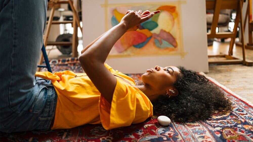 Słuchawki dokanałowe beyerdynamic Amiron 100 ANC Kremowy osoba ze smartfonem w dłoni aplikacja indywidualne ustawienia