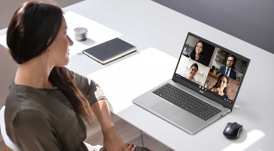 Kobieta przy stole z laptopem ACER Extensa 15, na którym widoczna jest grupa osób. - 14-calowy wyświetlacz WUXGA