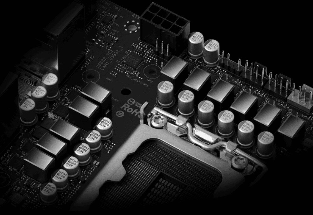 Płyta główna ASROCK B860I WiFi Zbliżenie na sekcję zasilania wokół gniazda procesora z widocznymi licznymi dławikami oraz srebrnymi kondensatorami