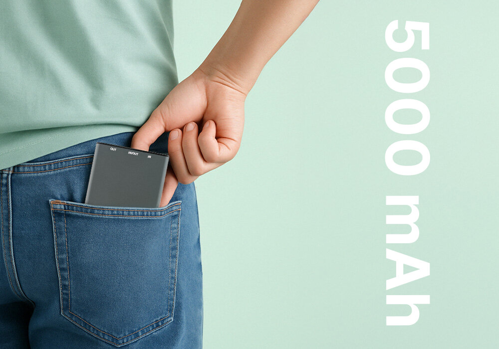 Powerbank QUALO Recycling QRPB5-12-18 5000 mAh Szary, Zapas mocy dla zabieganych, Osoba wkłada powerbank'a do tylniej kieszeni spodni, obok napis w tle o parametrze pojemności powerbanka
