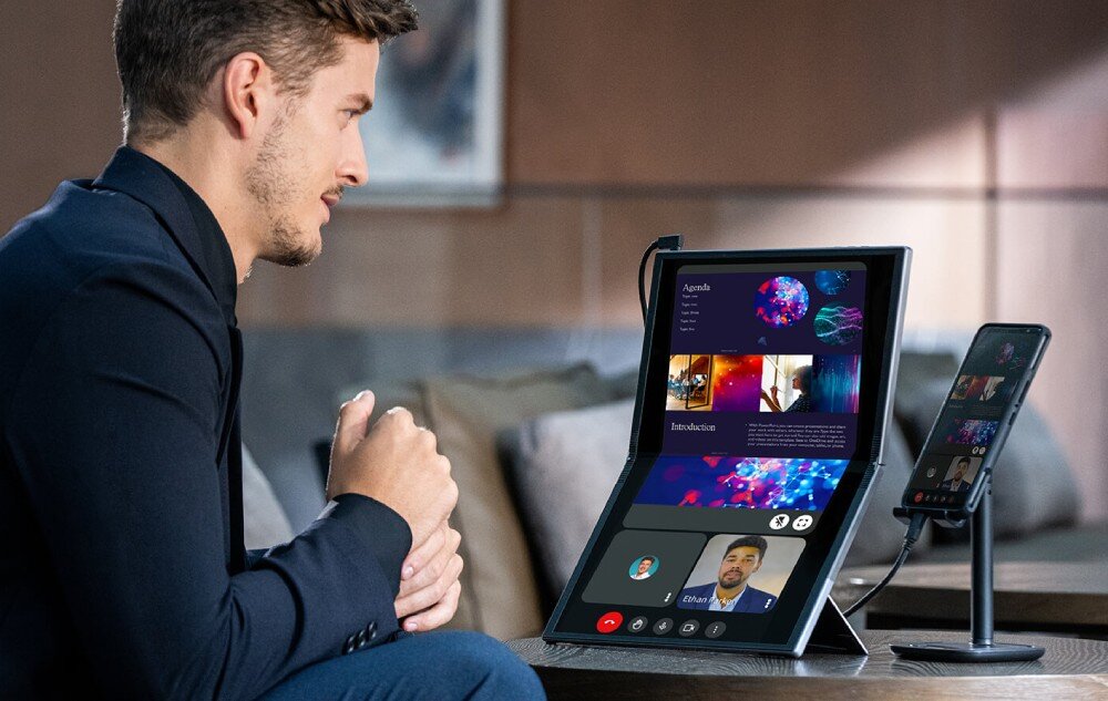 Monitor ASUS ZenScreen Fold MQ17QH Mężczyzna siedzący przy stole korzysta z rozłożonego monitora i smartfona podczas wideokonferencji, podpórka, orientacja, gwint statywowy