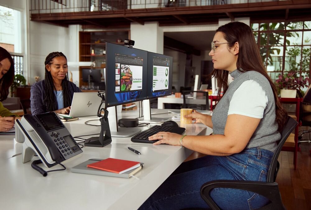 Słuchawka HP Poly Voyager Legend 50 VOY502 konstrukcja mono orientacja przestrzenna, osoba z założoną słuchawką pracująca w biurze