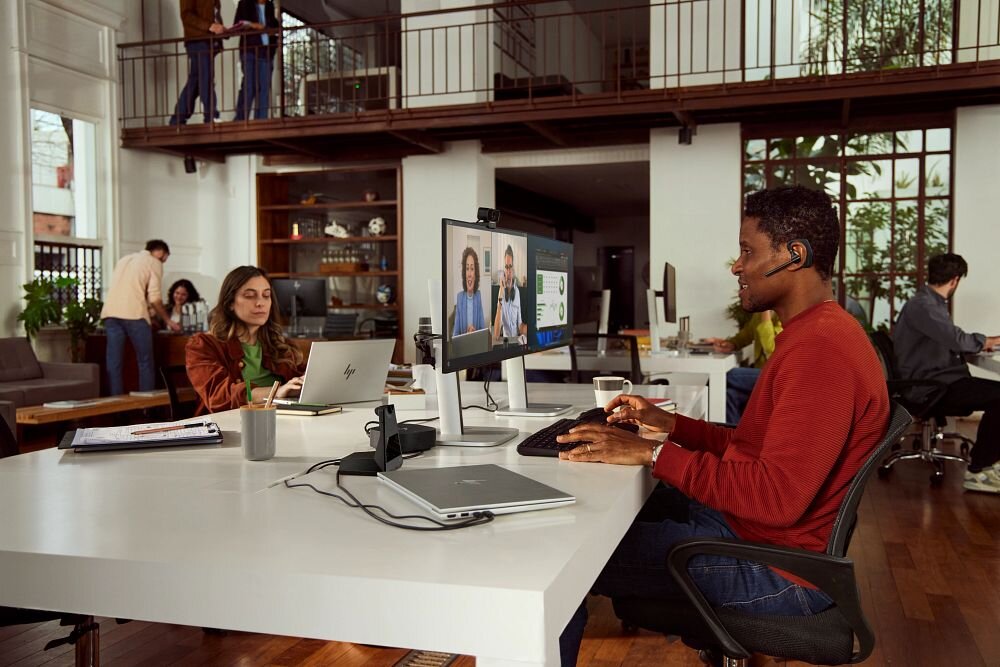 Słuchawka HP Poly Voyager Legend 50 VOY502 inteligentne czujniki sterowanie połączeniami, osoba z założoną słuchawką pracująca w biurze