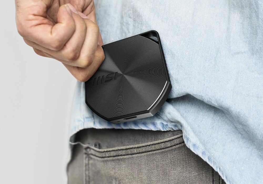 Dysk MSI Datamag 20Gbps 2TB Osoba wkładająca kompaktowy, czarny dysk do przedniej kieszeni spodni jeansowych, co podkreśla jego kieszonkowy rozmiar, waga, pojemność, współczynnik TBW