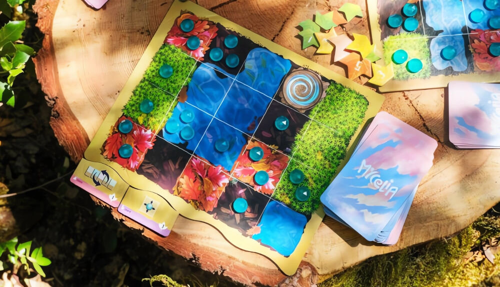 Gra planszowa RAVENSBURGER Mycelia 22898 elementy gry rozłożone na pienku historia rozgrywka ulepszanie talii oczyszczanie planszy tryb dla 1 gracza karty rozszerzeń dodatkowe urozmaicenia