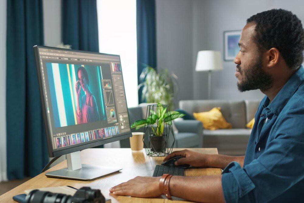 Procesor INTEL Core Ultra 5-225F Mężczyzna przy biurku w domowym otoczeniu edytujący zdjęcia na monitorze z widocznym aparatem fotograficznym obok, technologie, Thunderbolt, możliwości