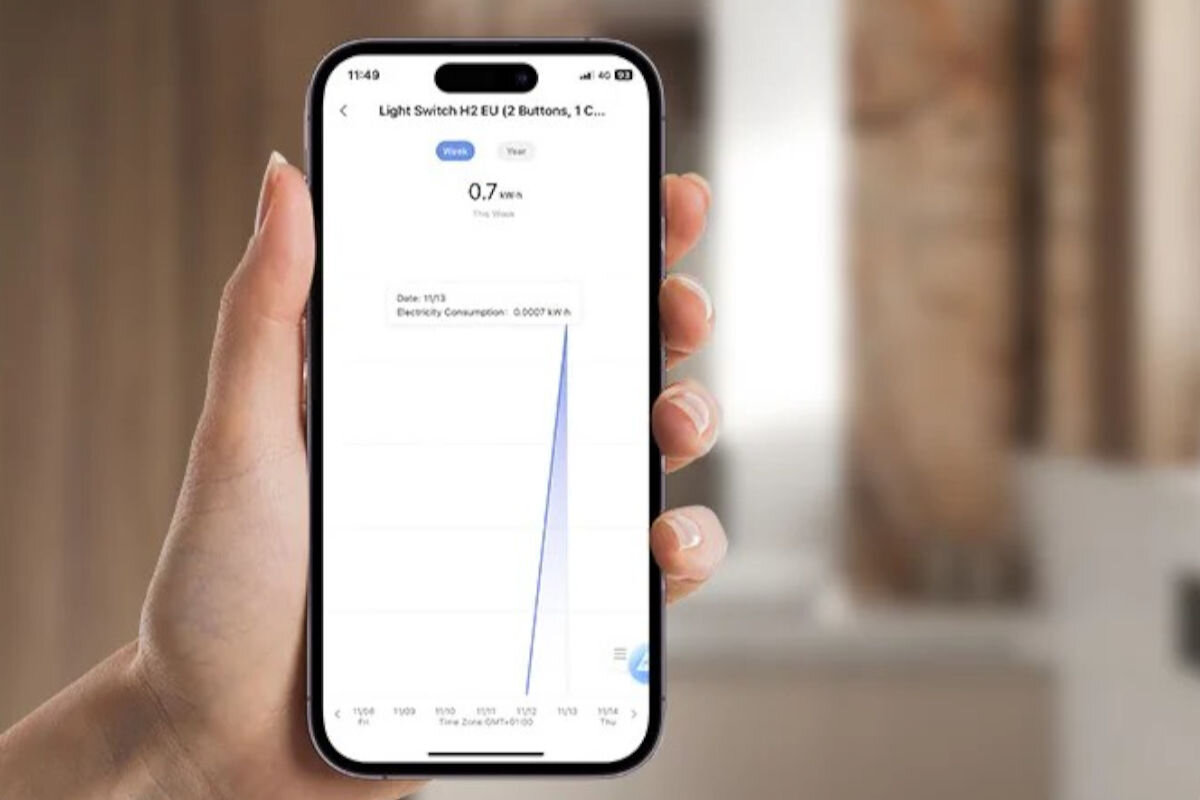 Inteligentny przełącznik AQARA Light Switch H2 EU WS-K08D, monitorowanie, zużyce energii, raporty, smartfon w dłoni, na smartfonie włączona aplikacja licząca zużycie energii