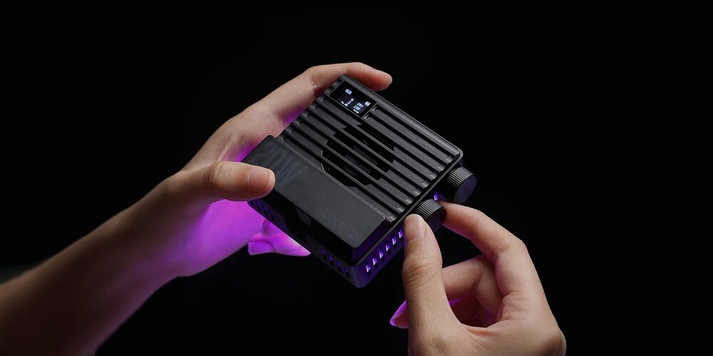 Lampa LED Ulanzi LE20 trzymana w dłoniach podczas regulacji