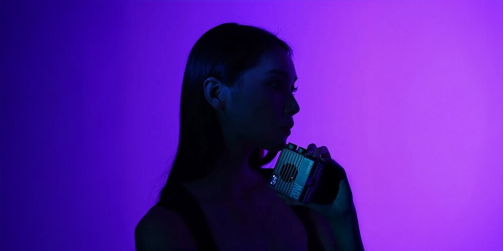 Lampa LED Ulanzi LE20 w ręce modelki obok twarzy