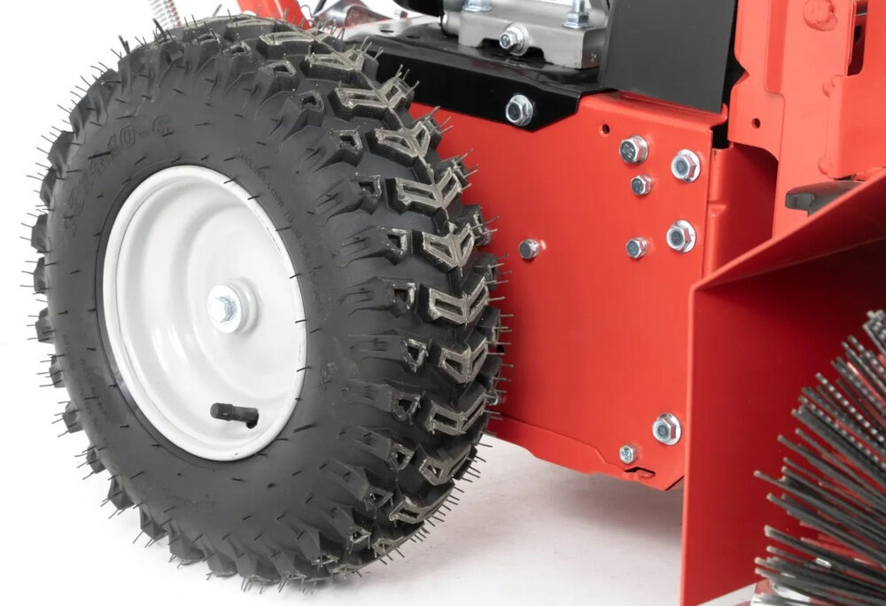 Zamiatarka spalinowa FAWORYT KZ80-196L zbliżenie na koło koła o średnicy 33 cm wygodne prowadzenie na nierównych nawierzchniach waga około 69,1 kg stabilizuje urządzenie podczas pracy zamiatarka prowadzi się pewniej bezpieczeństwo precyzja sprzątania