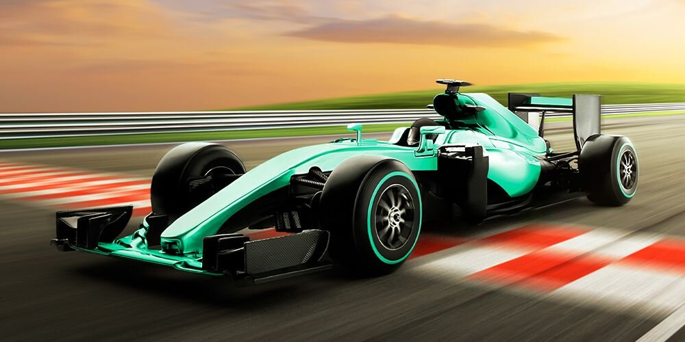 Zielony bolid Formuły 1 na torze wyścigowym przy zachodzie słońca, symbolizujący płynność obrazu dzięki odświeżaniu 120 Hz w laptopie ASUS Zenbook 14.