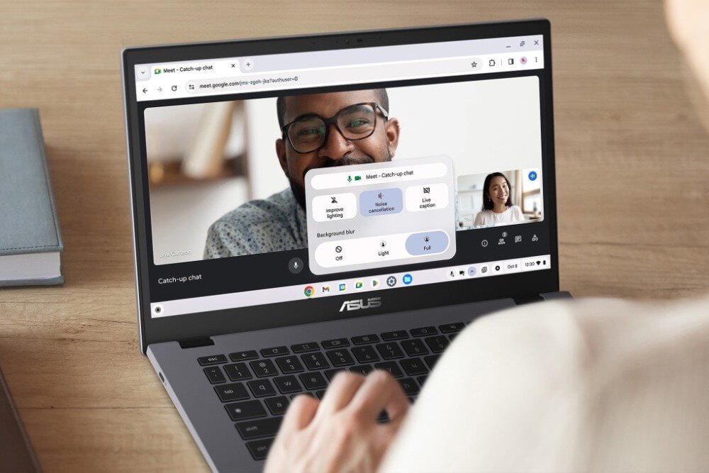 Laptop ASUS Chromebook Plus CB3402CVA-MW0529 Widok zza ramienia osoby korzystającej z laptopa podczas wideokonferencji. Na ekranie widoczne dwie osoby rozmawiające ze sobą, a po środku panel ustawień aplikacji do spotkań online, opis