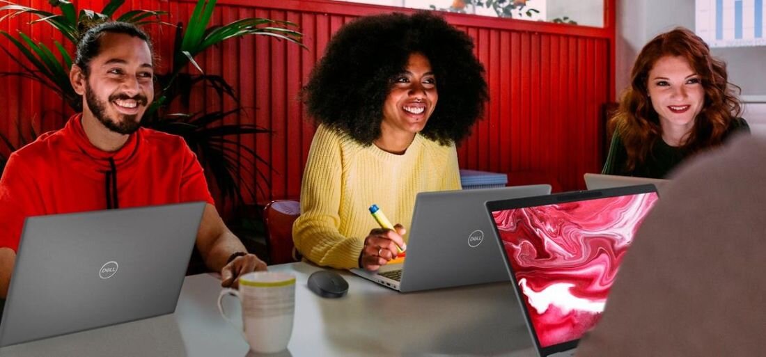 Trzy osoby przy stole, korzystające z laptopów, w tym DELL Latitude 5550. - Bateria o pojemności 54 Wh, ExpressCharge 