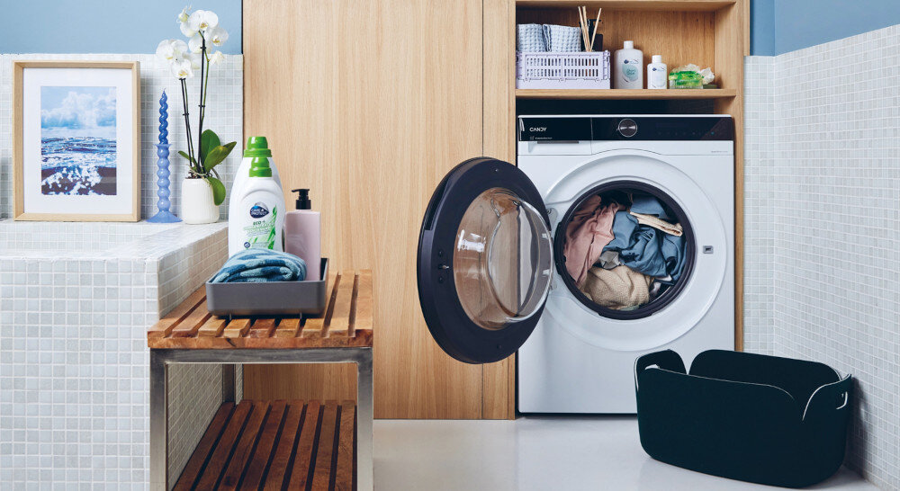Pralko-suszarka CANDY BWSD 6106B8-S zdjęcie łazienka kosz na pranie otwarte drzwiczki bęben załadunek odzież 10 kg dla prania i 6 kg dla suszenia AI Silent Motion Codzienne pranie w mniej niż godzinę ProActive Eco Wash SpeedDrive Inverter Czyste pranie nawet w 14 minut Wyświetlacz LCD w języku polskim funkcja autodozowania Soft Drum Clean Shield Smart Spray Program Anty Smog Cichy program prania nocnego Zdalne sterowanie suszarką dzięki aplikacji hOn i Wi-Fi