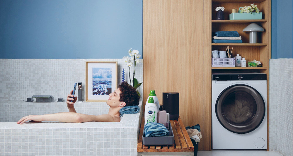 Pralko-suszarka CANDY BWSD 6106B8-S lifestyle łazienka zabudowa wanna mężczyzna kąpiel obraz ręczniki Wyjątkowo cicha AI Silent Motion mniejsze wibranie praca w nocy 72 dB
