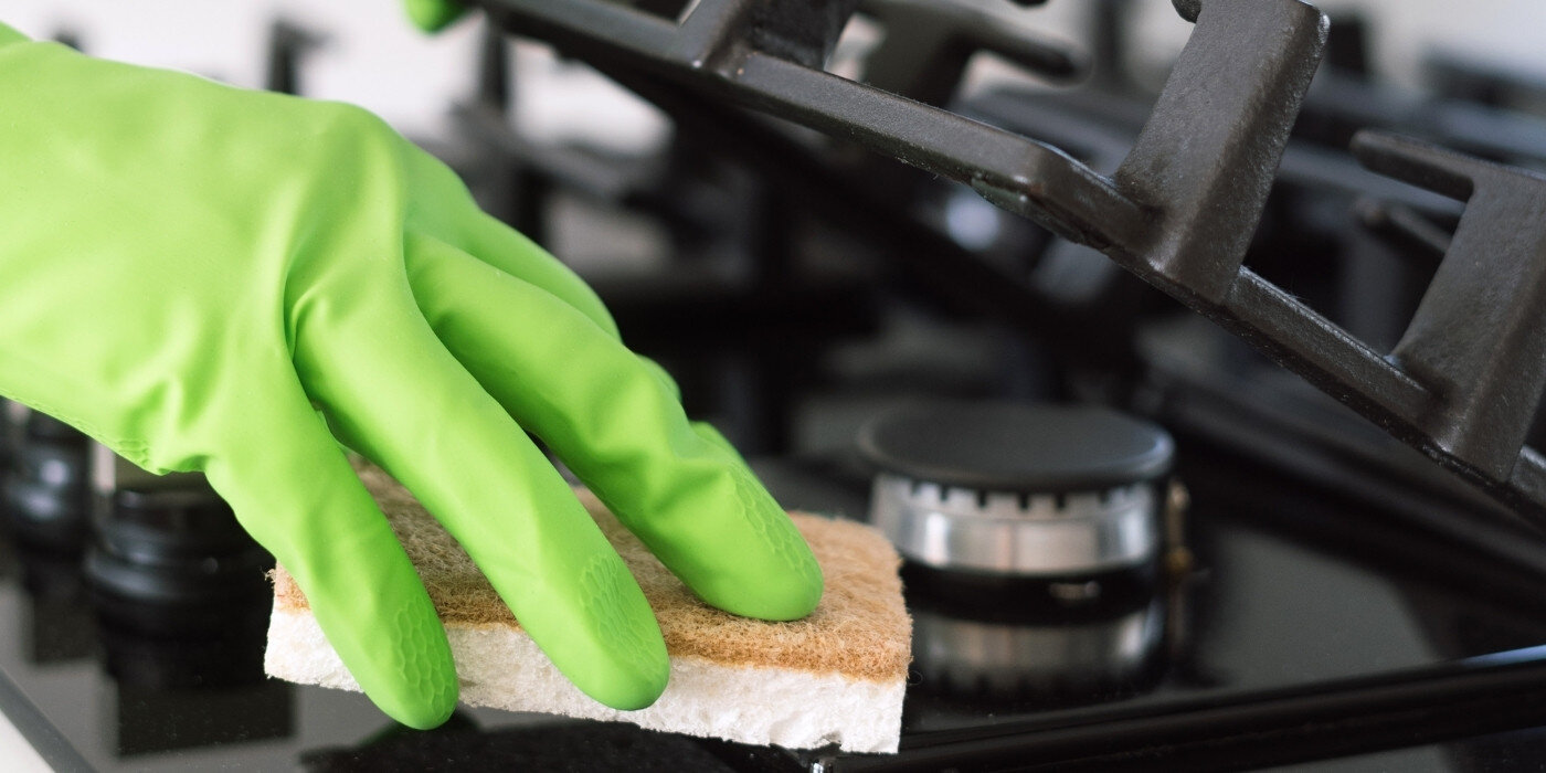 PŁYTA CANDY CVFG6BF4PB lifestyle wizualizacja dłoń w zielonej rękawiczce z gąbką mycie płyty Łatwe czyszczenie gładka powierzchnia