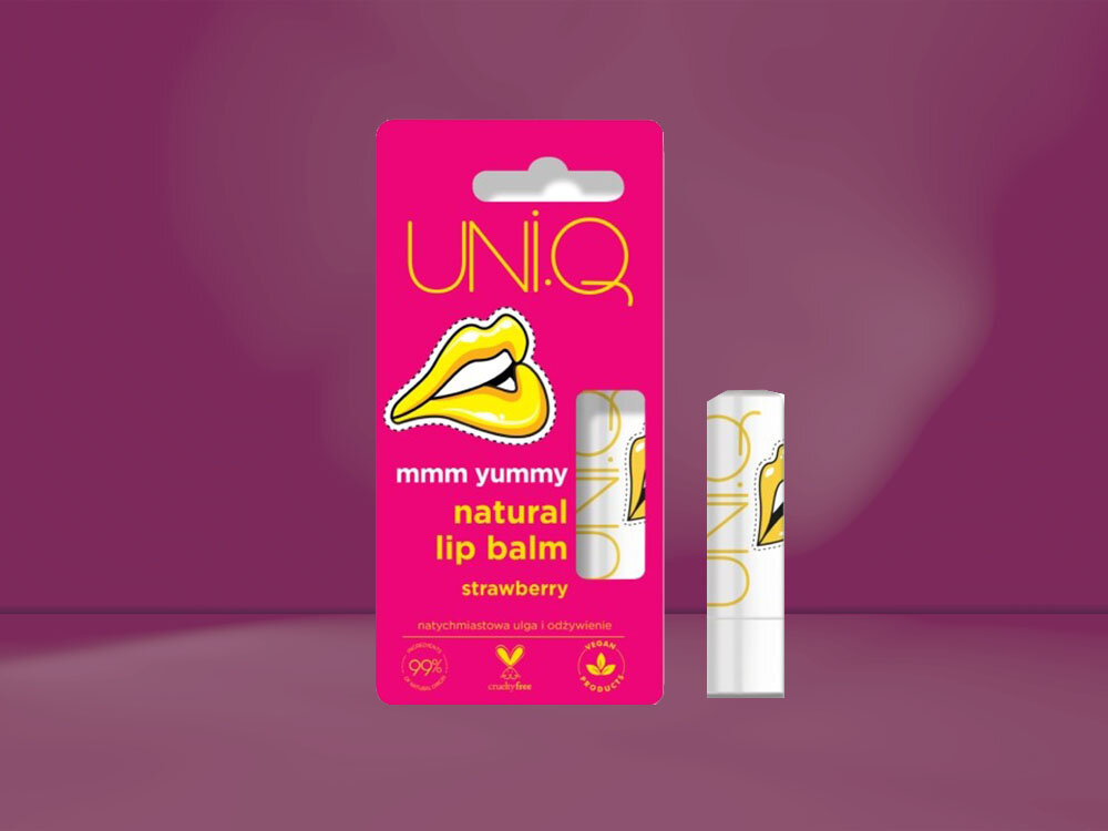 Opakowanie balsamu do ust UNI.Q Truskawka 5 g z grafiką ust i napisem \'mmm yummy natural lip balm strawberry\'. Widoczny jest również sam balsam w białym opakowaniu z podobnym wzorem.