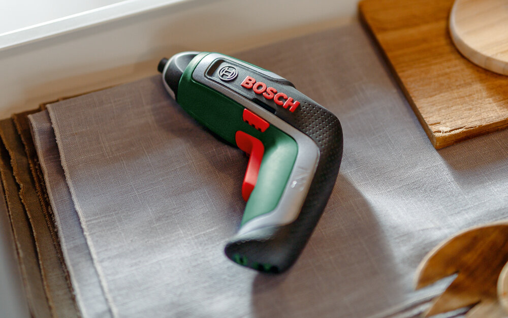 Wkrętak akumulatorowy BOSCH IXO 7 3.6V 2Ah 06039E000B wkrętak leży w szufladzie na ściereczce wielofunkcyjne narzędzie wkręcanie i wykręcanie śrub bez wysiłku wygoda domowe naprawy