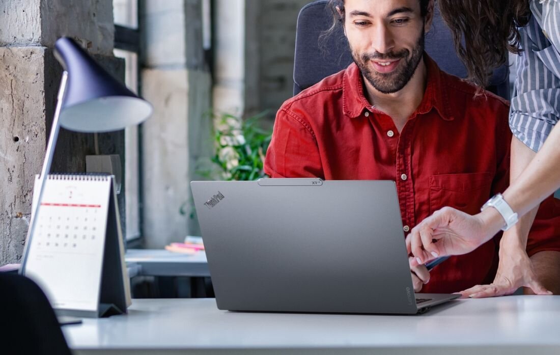 Współpracownicy podczas pracy na laptopach Lenovo ThinkPad w biurze przy wspólnym projekcie - Shield Mode  