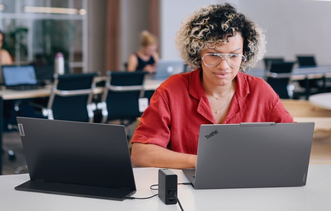 Kobieta pracująca na dwóch laptopach Lenovo ThinkPad podłączonych do stacji dokującej w biurze - Power Mode 
