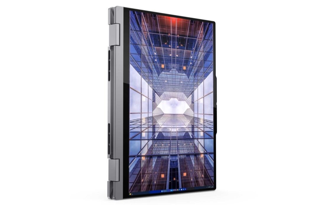 Laptop Lenovo ThinkBook 14 2-in-1 w trybie tabletu z ekranem prezentującym futurystyczną architekturę wysokich budynków w perspektywie worm's eye view z niebieskim niebem i chmurami, z certyfikatem wytrzymałości MIL-STD-810H, podkreślający trwałość konstrukcji. - Trwałość MIL-STD-810H