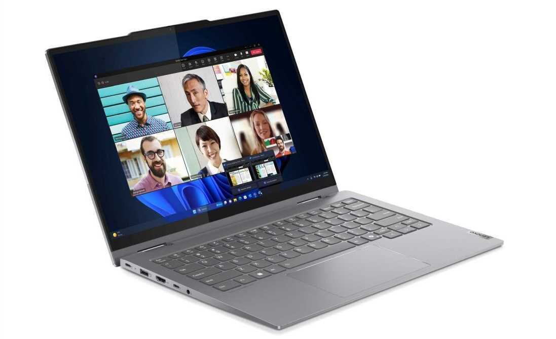 Laptop Lenovo ThinkBook 14 2-in-1 na białym tle podczas wideokonferencji, na ekranie sześć uczestników spotkania online w siatce 2x3, w tle nowoczesne wnętrze biurowe z panoramicznymi oknami. - DDR5 SSD M.2 PCIe 4.0x4 NVMe