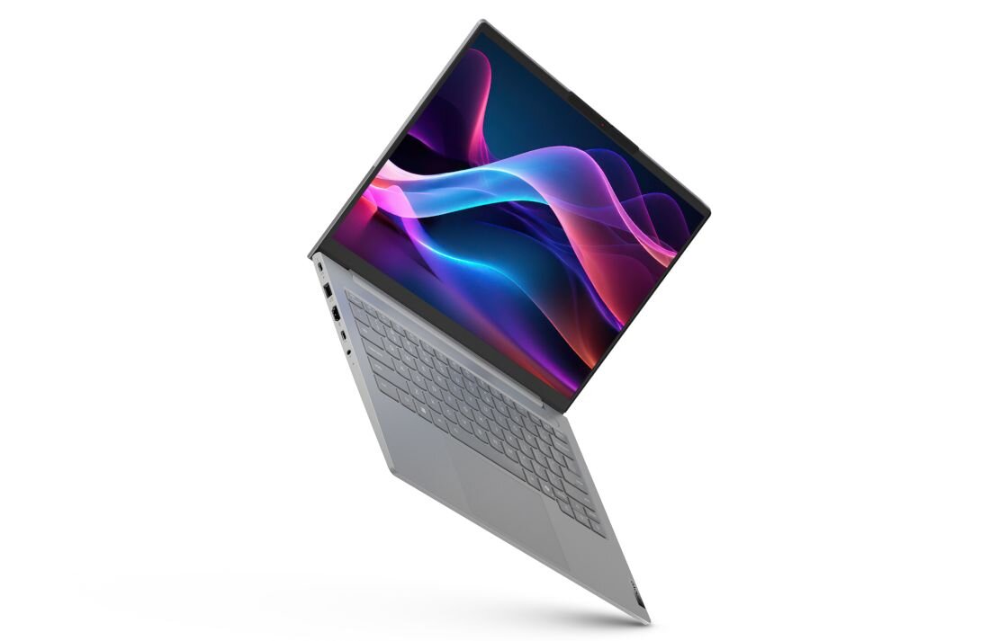 Laptop Lenovo ThinkBook 14 w srebrnej obudowie z ekranem prezentującym dynamiczną, abstrakcyjną tapetę z falami świetlnymi w kolorach fioletu i błękitu, podkreślający wydajność procesora Intel Core. - Intel Core, RAM DDR5, dysk SSD