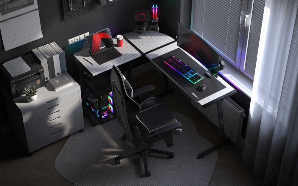 Biurko gamingowe HUZARO Hero 6.0 RGB Biały prezentacja biurka w pokoju o ciemnych ścianach na biurku akcesoria i komputer przy biurku fotel blat w kształcie litery L narożnik pokoju ergonomiczny kształt wygoda łatwy dostęp do elementów stanowiska duża powierzchnia robocza komfort
