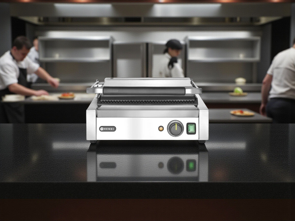 Grill elektryczny HENDI Panini 263655, lokal gastronomiczny, street food, intensywna praca, wydajność, Grill Panini Hendi 263655 w profesjonalnej kuchni, niska perspektywa, w tle kucharze przy pracy.