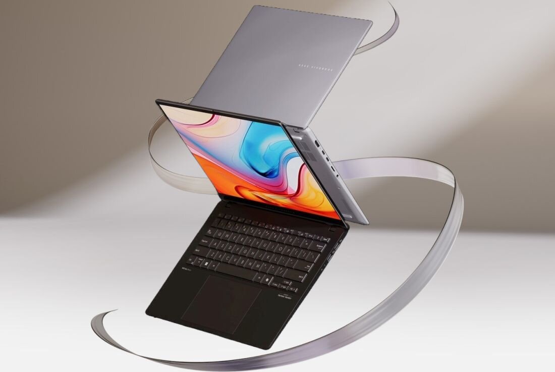 Laptop ASUS VivoBook S 14 z otwartym ekranem na białym spiralnym tle z kolorowymi wstążkami w odcieniach różu, błękitu i pomarańczy