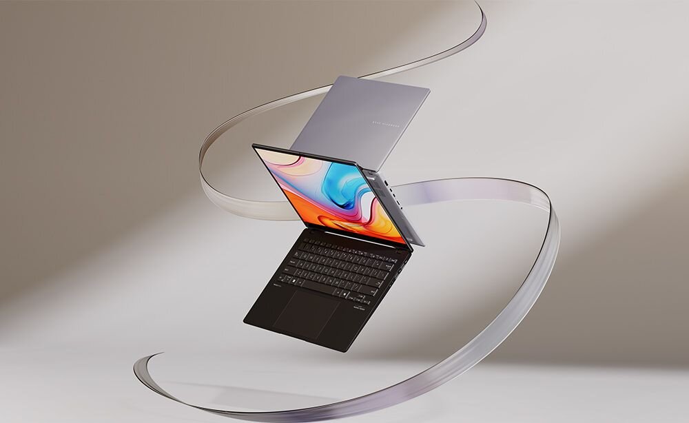 Laptop ASUS Vivobook S 16 OLED unoszący się w powietrzu na tle przezroczystych, falujących wstęg w odcieniach fioletu i różu, ekran prezentuje kolorową abstrakcyjną grafikę z niebieskimi, pomarańczowymi i różowymi wirami, srebrna obudowa z logo ASUS, dynamiczna kompozycja podkreślająca lekkość i elegancję urządzenia.