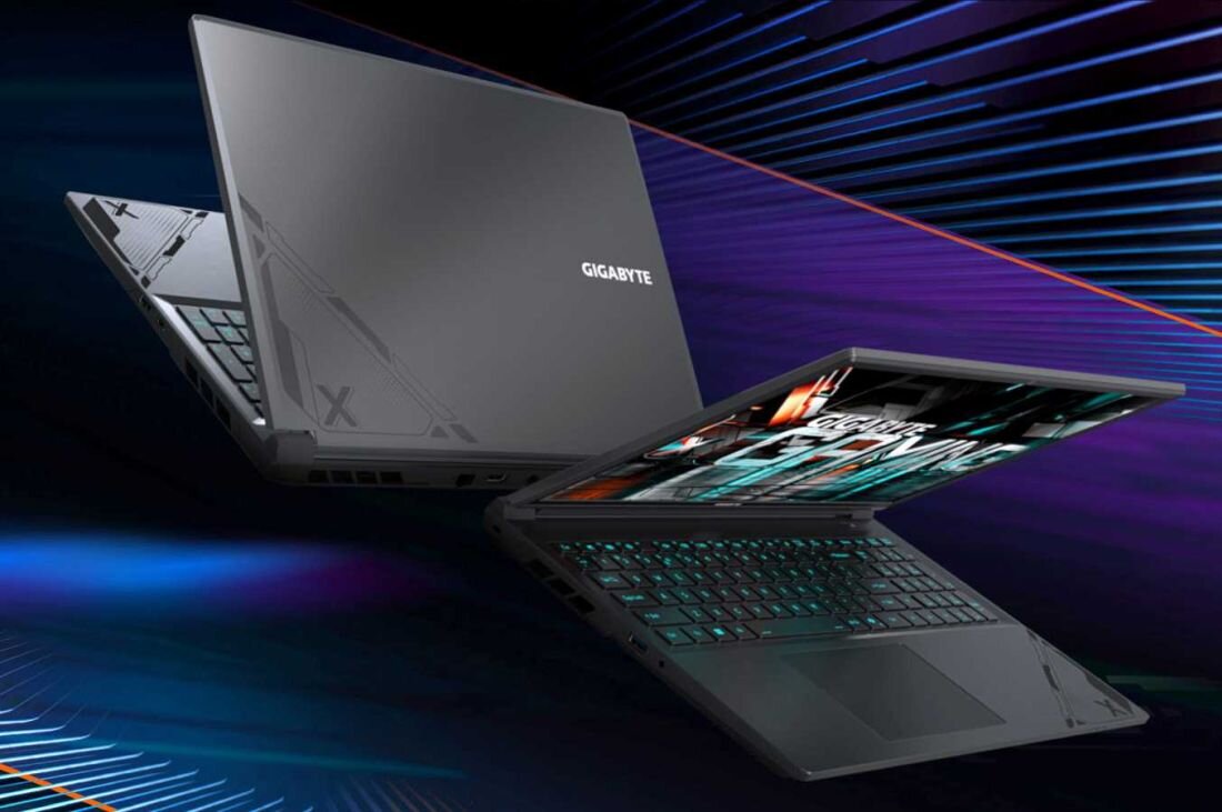 Dwa laptopy GIGABYTE G6X na tle dynamicznych, kolorowych linii – jeden zamknięty, drugi otwarty z podświetlaną klawiaturą, prezentacja mobilności i pojemnej baterii 73 Wh. - bateria o pojemności 73 Wh