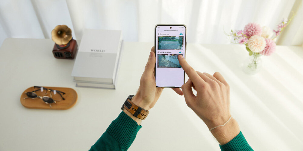 Kamera IMILAB EC6 Dual Zewnętrzna, Wi-Fi, Kamera obrotowa osoba trzyma telefon w dłoniach z widoczną aplikacją intuicyjna aplikacja Mi Home pełna kontrola nad monitoringiem domu powiadomienia w czasie rzeczywistym szybka reakcja technologia Wi Fi 6 stabilne i płynne przesyłanie obrazu regulacja kąta widzenia modyfikacja parametrów