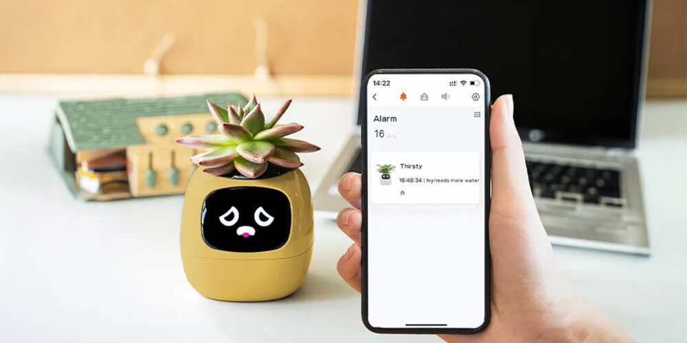 Doniczka inteligentna PLANTSIO IVY Wi-fi Żółty doniczka na stole obok telefon z włączoną aplikacją aplikacja IVY spersonalizowane wskazówki przypomnienie o podlewaniu analiza stan rośliny monitoruje kluczowe dane środowiskowe dostosowuje zalecenia do konkretnej rośliny integruje się z systemem Tuya IoT zdalne monitorowanie i kontrolę roślin