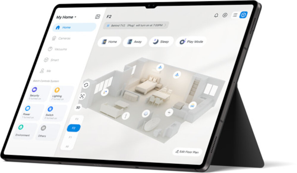 Tablet z wyświetlonym interfejsem aplikacji do zarządzania inteligentnym domem, pokazującym plan pomieszczenia i opcje sterowania urządzeniami. Na ekranie widoczne są ikony i teksty takie jak \'Home\', \'Away\', \'Sleep\', \'Play Mode\'.