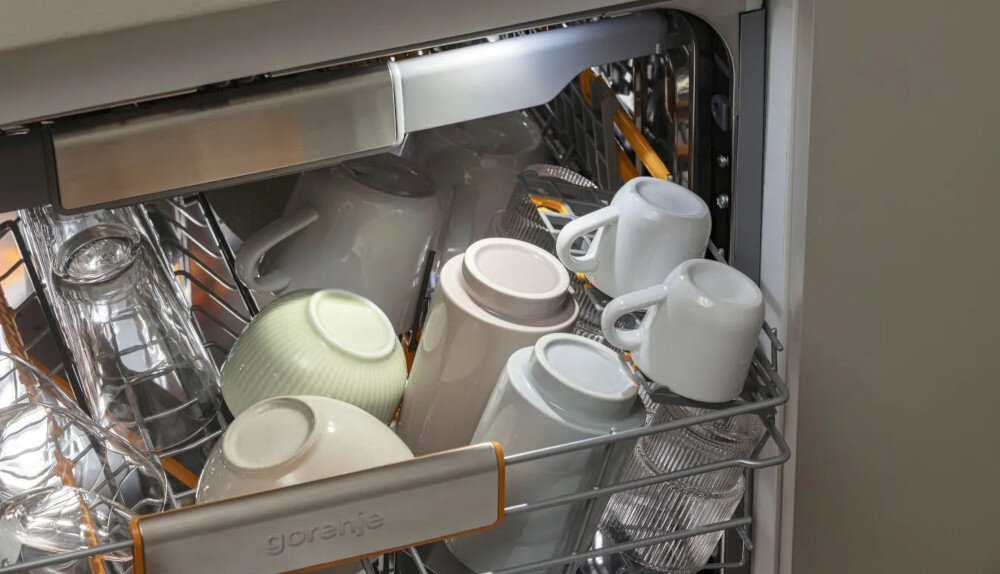 ZMYWARKA GORENJE GV693A65AD Na zdjęciu widoczny jest górny kosz zmywarki z ustawionymi filiżankami, kubkami i szklankami. Kosz oświetlony jest lampką LED, a w tle widać elementy metalowych ścianek urządzenia zmywarka oświetlenie LED wnętrze łatwy załadunek łatwy rozładunek eleganckie oświetlenie