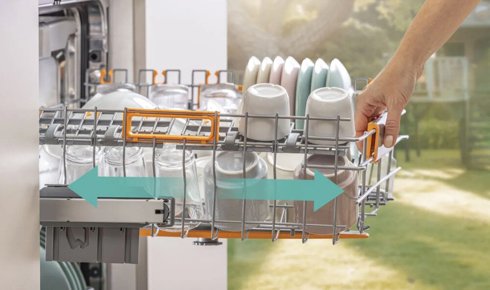 ZMYWARKA GORENJE GV693A65AD Na zdjęciu pokazano rękę wysuwającą górny kosz zmywarki, w którym ułożone są szklanki i kubki. Kierunek przesuwania kosza został zaznaczony szeroką strzałką zmywarka łatwy załadunek górny kosz płynny ruch prowadnice kulkowe szybkie wkładanie wyjmowanie naczyń