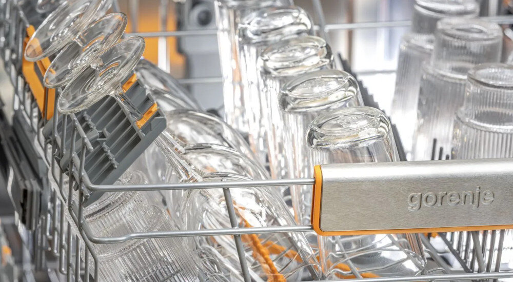 ZMYWARKA GORENJE GV693A65AD Na zdjęciu widać kosz zmywarki w którym ustawiono szklane kieliszki oraz zwykłe szklanki. Kieliszki są zabezpieczone specjalną uchylną nakładką, która chroni je podczas mycia UltraClean program mycia kieliszki szklanki delikatne szklane naczynia niższa temperatura kryształowe kieliszki