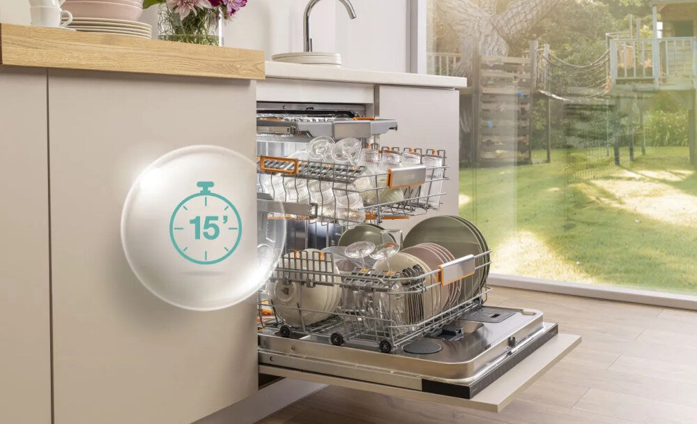 ZMYWARKA GORENJE GV693A65AD Na zdjęciu znajduje się otwarta zmywarka z ułożonymi w koszach szklankami, kieliszkami i talerzami. Na froncie szafki widoczna jest grafika przedstawiająca stoper z liczbą „15”, co sugeruje szybki, 15-minutowy program mycia program 1 godzina SpeedWash szybkie mycie 15 minut duża ilość naczyń imprezy