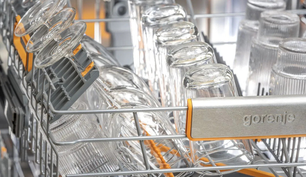 ZMYWARKA GORENJE GV693A65AD Zdjęcie przedstawia kosz zmywarki marki Gorenje, w którym umieszczone są kieliszki na specjalnych mocowaniach oraz szklanki ustawione dnem do góry. Stalowy element z logo marki podkreśla solidność i elegancję konstrukcji kosza uchwyty na kieliszki bezpieczne mocowanie gumowe zabezpieczenie wyższe szklanki elastyczne wsporniki różna liczba szklanek