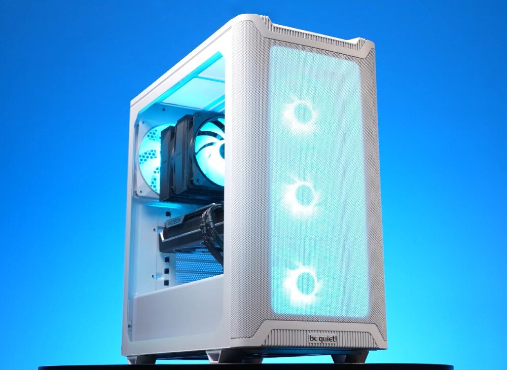 Biała obudowa komputerowa z trzema podświetlanymi wentylatorami na przednim panelu i logo \'be quiet!\' na dole. Wnętrze obudowy jest widoczne, z zamontowanymi komponentami i niebieskim podświetleniem.