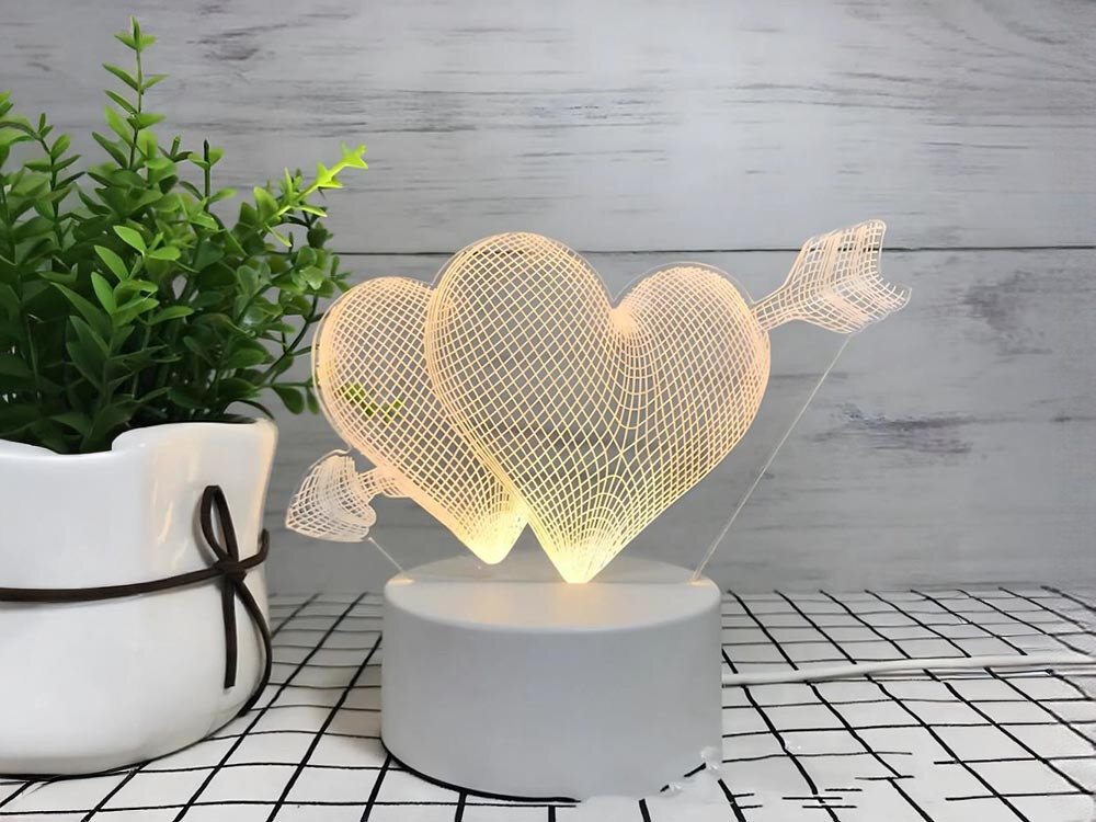 Lampka nocna EXTRALINK Przebite serca 3D EX.24107 USB, iluzja, akryl, wzory, atmosfera, Biała lampka nocna 3D z dwoma sercami i strzałą na stoliku przy wazonie.