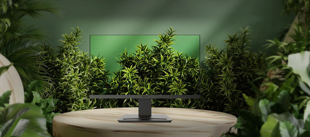 Monitor MSI Pro MP223 E2 21.45 cala 1920x1080px 100Hz 1 ms [MPRT] pokazanie monitora wśród zielonych liści na stoliku zielona ściana Energy Star 8.0 tryb oszczędzania energii redukcja zużycia prądu dbanie o planetę