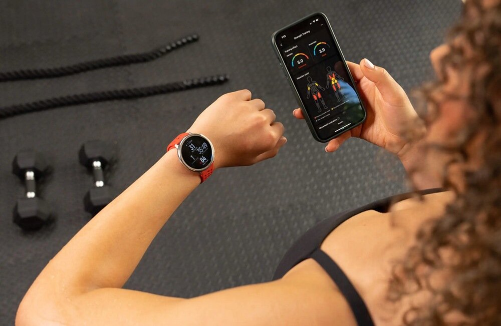 Smartwatch AMAZFIT Active 2 kobieta na siłowni sprawdza dane na zegarku i smartfonie