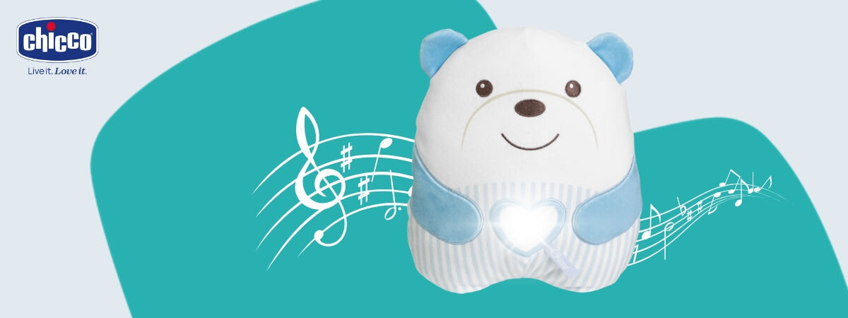 Maskotka CHICCO First Dreams Misiek Brzuszek 00012266200000 Niebieski z włączonym światełkiem na brzuchu w tle pięciolinia z nutami