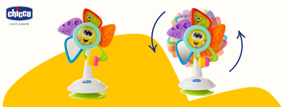 Zabawka edukacyjna CHICCO Baby Senses Kolorowy wiatraczek 00009710000000 biało żółte tło zabawka wiatrak kolorowe elementy pokazane strzałki że się obraca Miękka tekstura tworzywa bezpieczna dla skóry malucha różne tekstury rozwijanie zdolności dotykowych stymulacja zmysłów przyssawka do krzesełka do karmienia