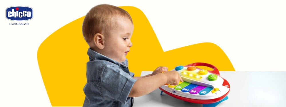 Zabawka pianino CHICCO 00012242000000 biało żółte tło dziecko klika klawisz na pianinie kolorowe klawisze podświetlenie  nauka przez zabawę